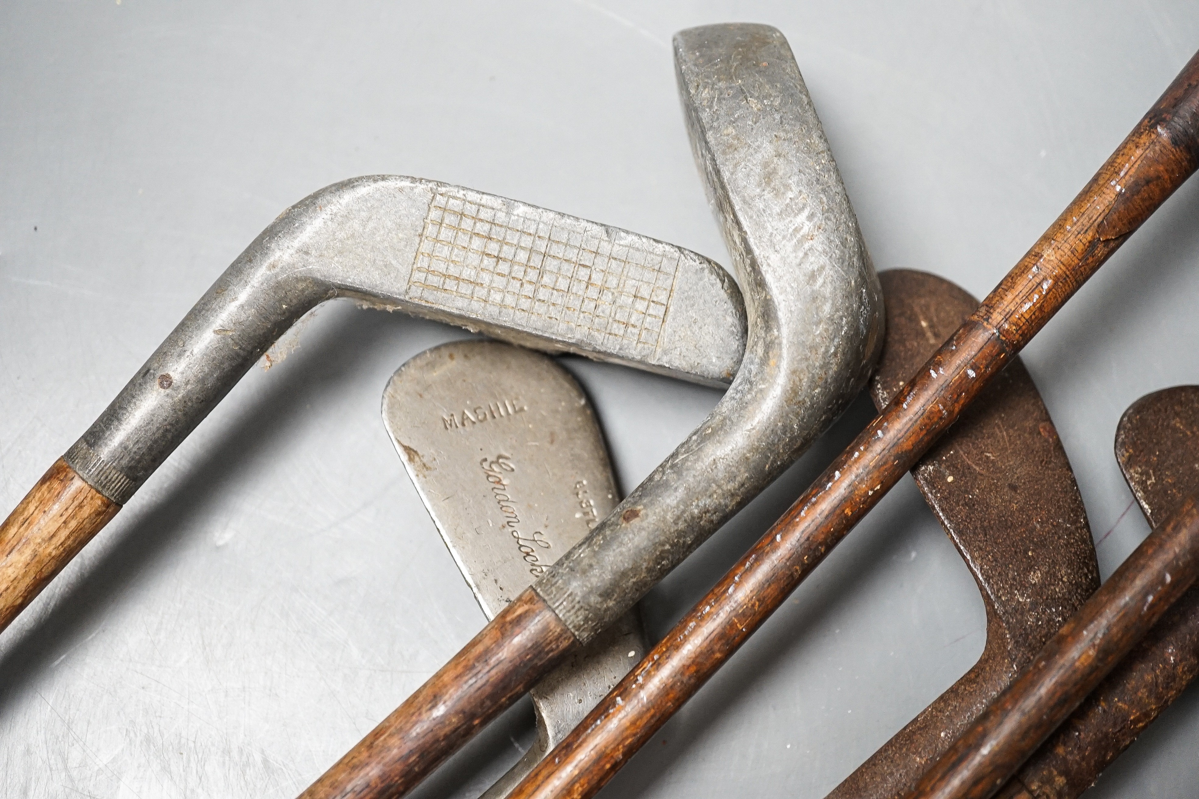 Golf clubs, knobkerrie in a leather carrier, carrier 50cms high.